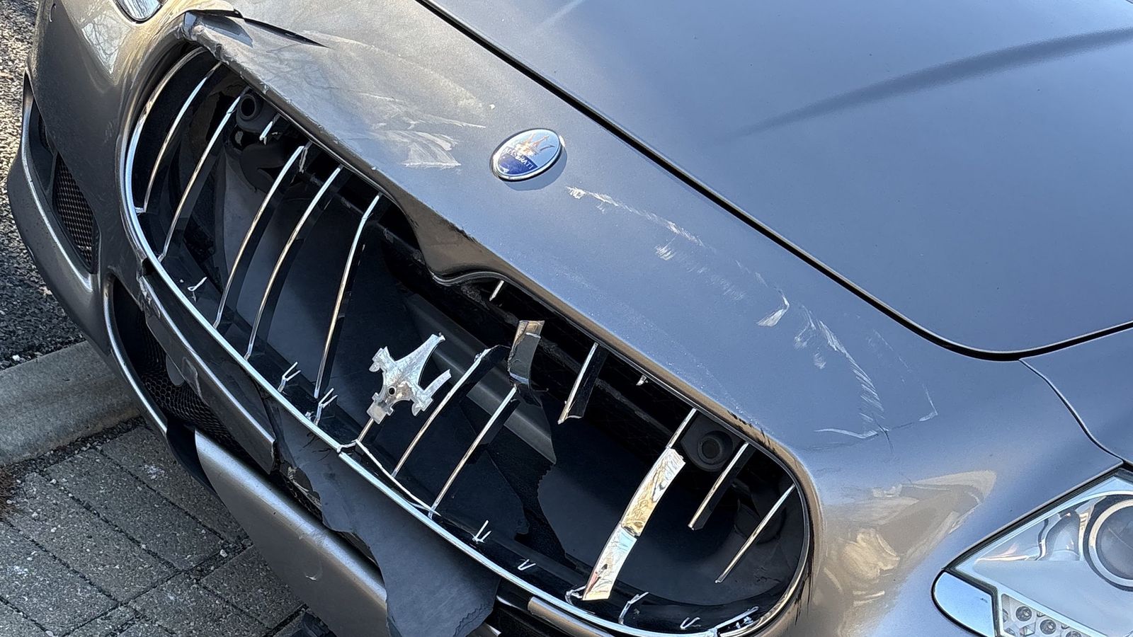 A Maserati with the grille smashed in and the front bumper torn open