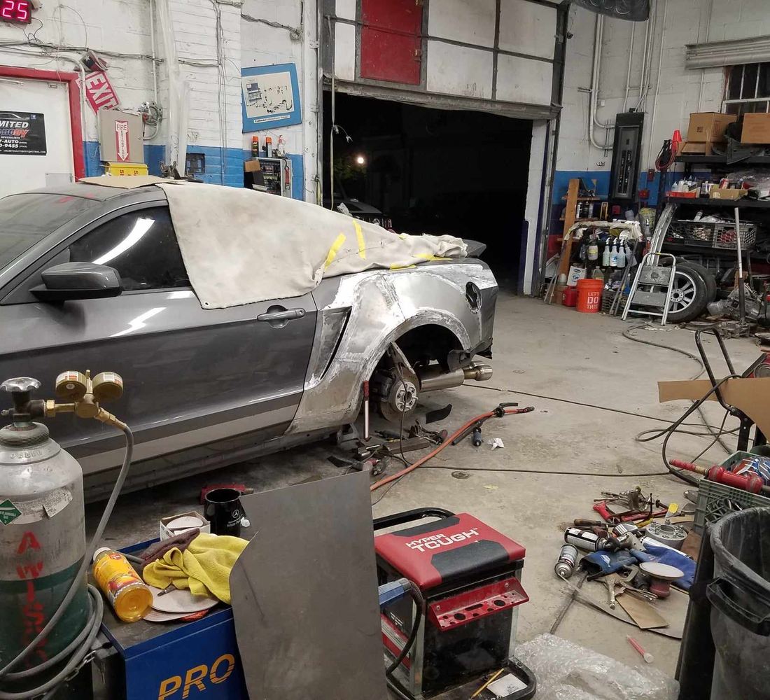 The workshop on West Main Street, a car stripped down mid-repair